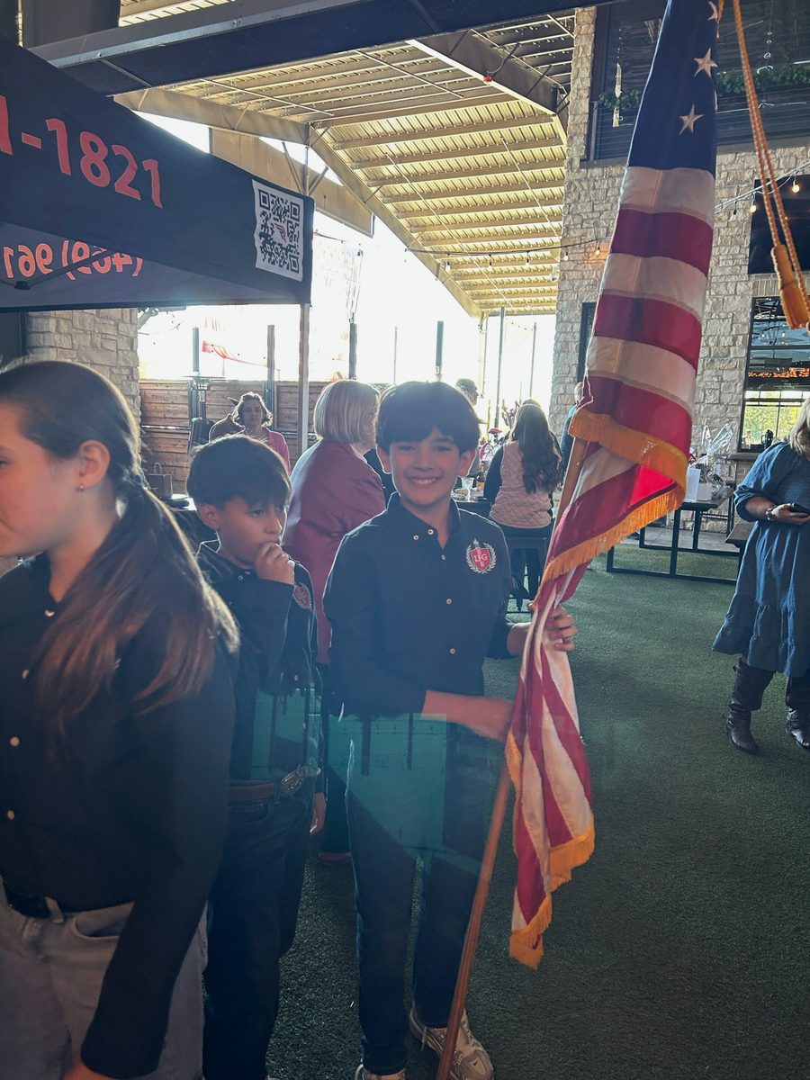 An LFG Academy student carrying the American flag at a community event