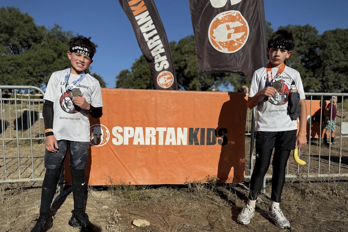 Two LFG Academy students holding their finisher medals after a Spartan race